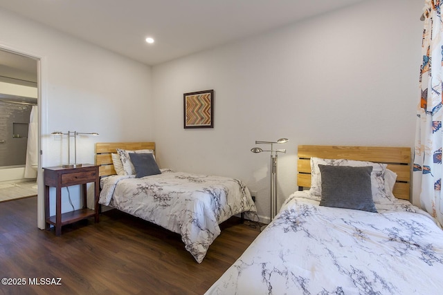 bedroom with dark hardwood / wood-style floors and ensuite bathroom