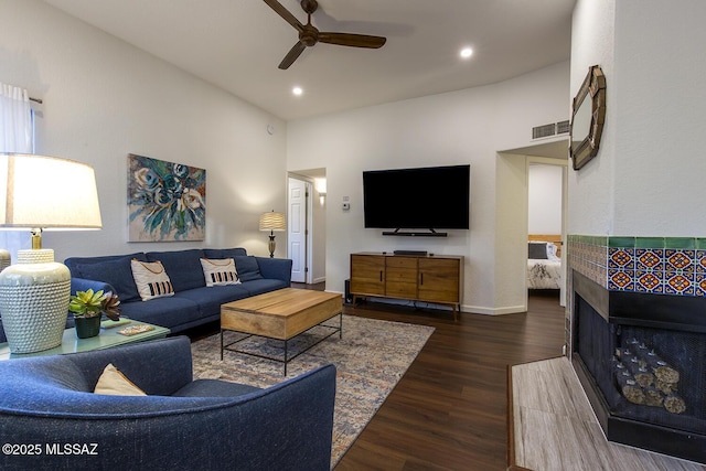 living room featuring a multi sided fireplace, a high ceiling, dark hardwood / wood-style floors, and ceiling fan