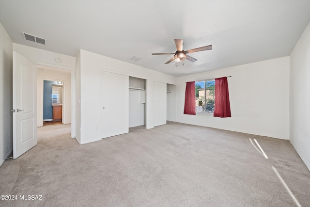 unfurnished bedroom with ceiling fan and light colored carpet