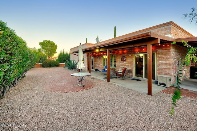 back house at dusk with a patio