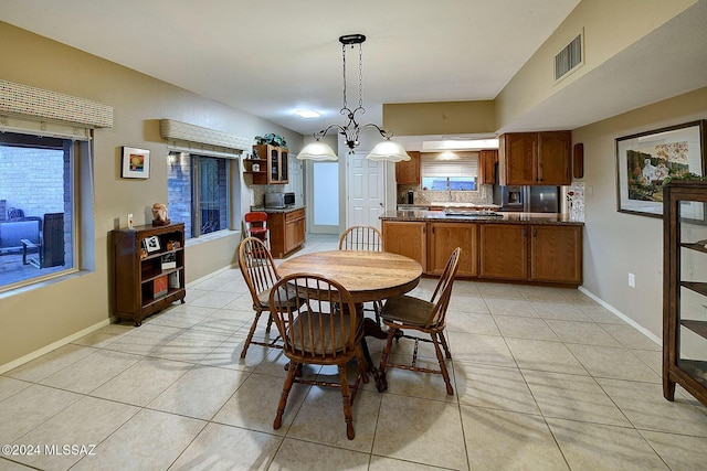 dining room featuring sink, a notable chandelier, and light tile patterned flooring