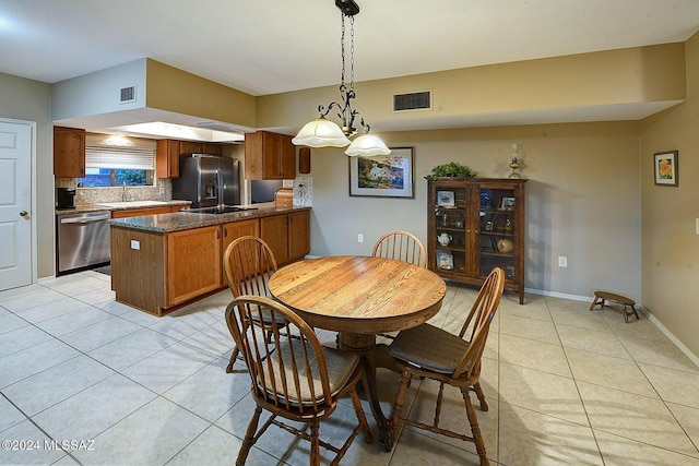 tiled dining area with a notable chandelier and sink