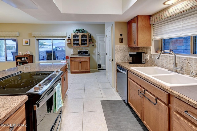 kitchen with tasteful backsplash, sink, light tile patterned floors, and stainless steel appliances