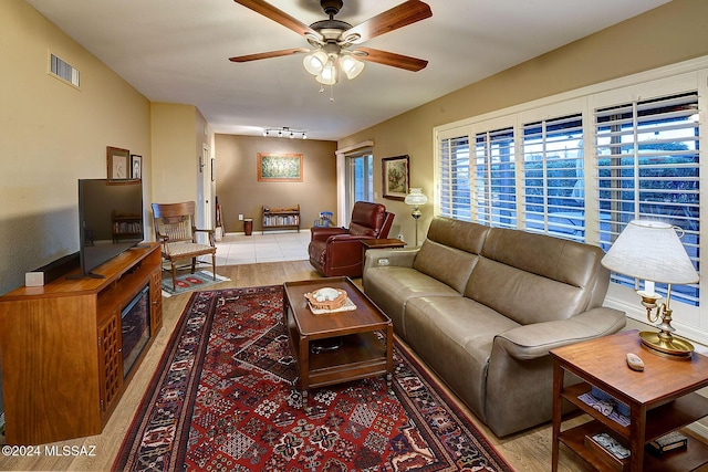 living room with ceiling fan, light wood-type flooring, and track lighting