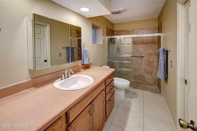 bathroom featuring tile patterned flooring, vanity, toilet, and a shower with shower door