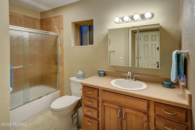 full bathroom with shower / bath combination with glass door, tile patterned flooring, vanity, and toilet