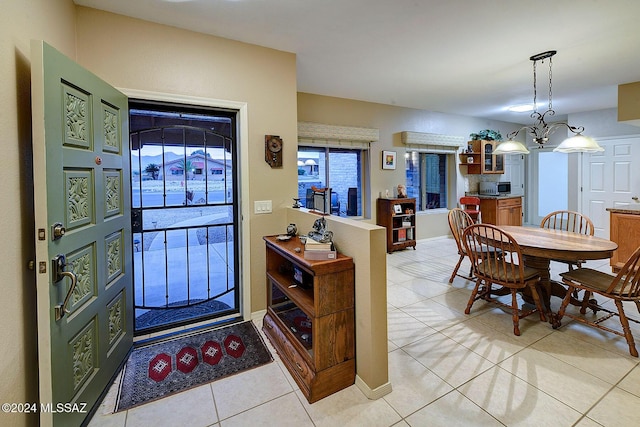 entryway with light tile patterned floors and a notable chandelier