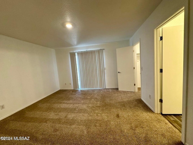 spare room featuring carpet and a textured ceiling