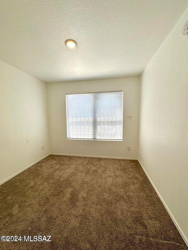 carpeted spare room featuring a textured ceiling