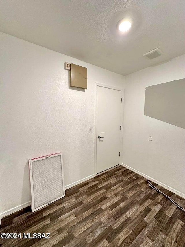 unfurnished room featuring a textured ceiling and dark hardwood / wood-style floors