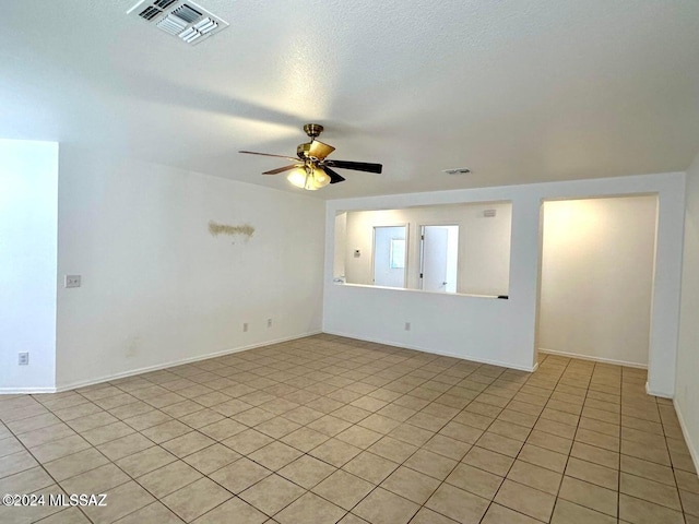 tiled spare room with ceiling fan