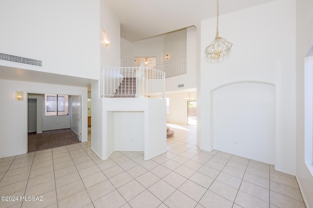 interior space featuring high vaulted ceiling and a notable chandelier