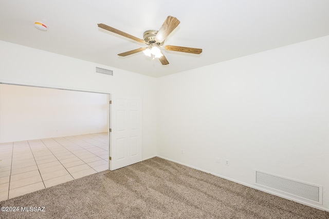 carpeted spare room with ceiling fan