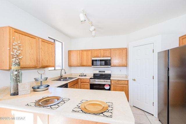 kitchen with kitchen peninsula, appliances with stainless steel finishes, light tile patterned floors, and sink