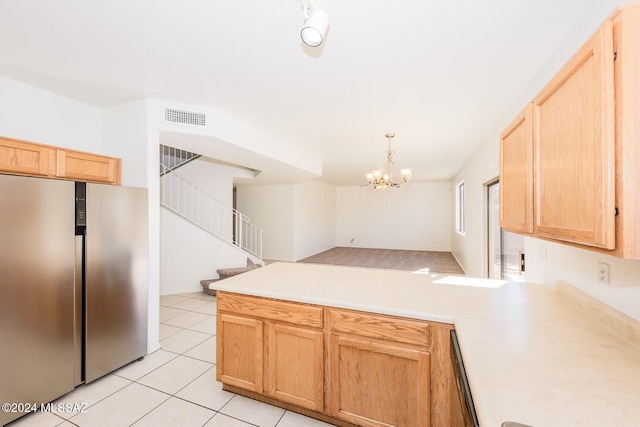 kitchen with hanging light fixtures, a notable chandelier, stainless steel fridge, light brown cabinetry, and light tile patterned flooring