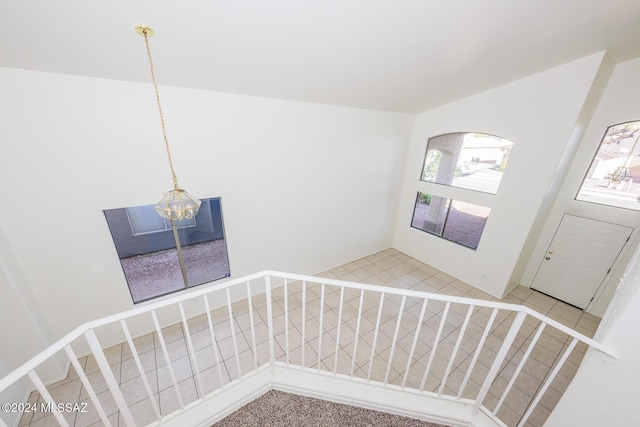 staircase with an inviting chandelier