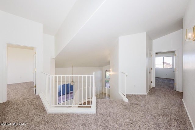 corridor with carpet flooring and vaulted ceiling