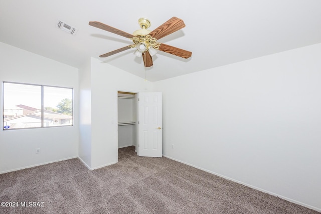 unfurnished bedroom featuring ceiling fan, a closet, light colored carpet, and vaulted ceiling