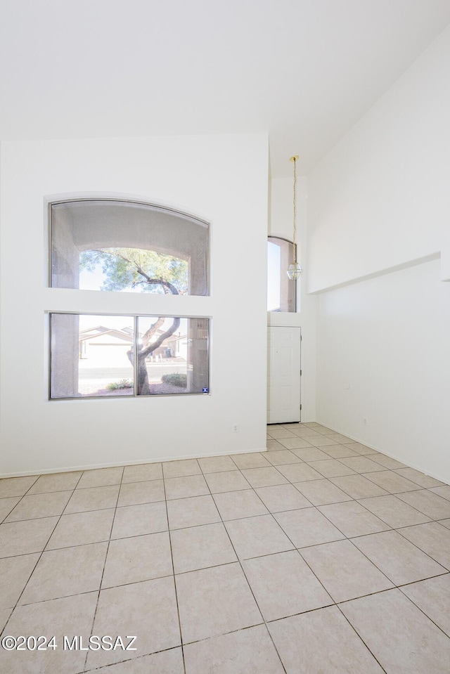 unfurnished room featuring light tile patterned floors and an inviting chandelier