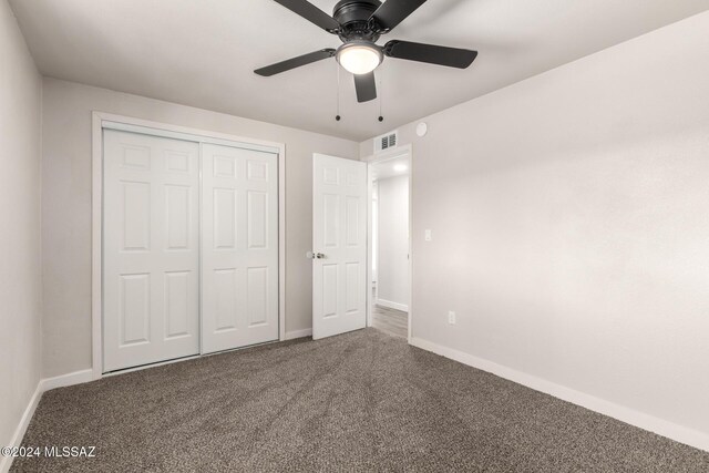 unfurnished bedroom with ceiling fan, a closet, and carpet floors