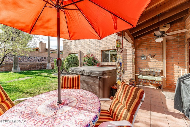 view of patio with ceiling fan and a hot tub