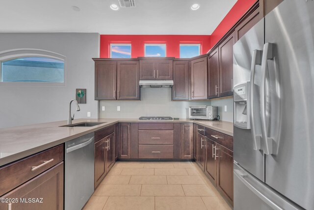 kitchen featuring light tile patterned floors, backsplash, stainless steel appliances, and sink