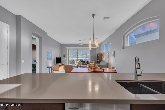 kitchen featuring decorative light fixtures, ceiling fan, and sink