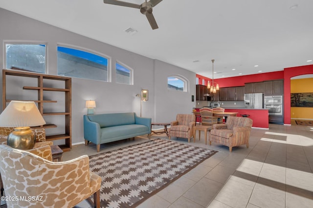 tiled living room featuring ceiling fan and a wealth of natural light