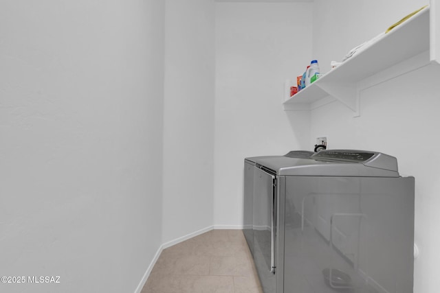 laundry room with washer and clothes dryer and light tile patterned floors