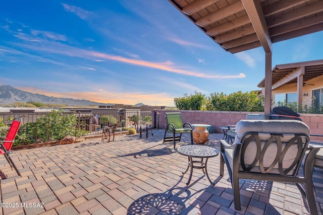 patio terrace at dusk featuring a mountain view