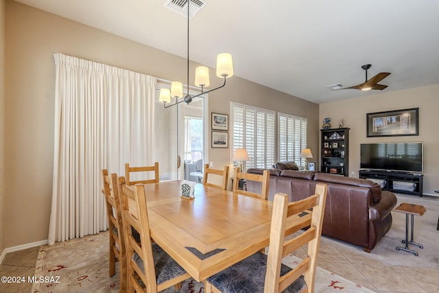 dining room featuring ceiling fan with notable chandelier and light tile patterned flooring