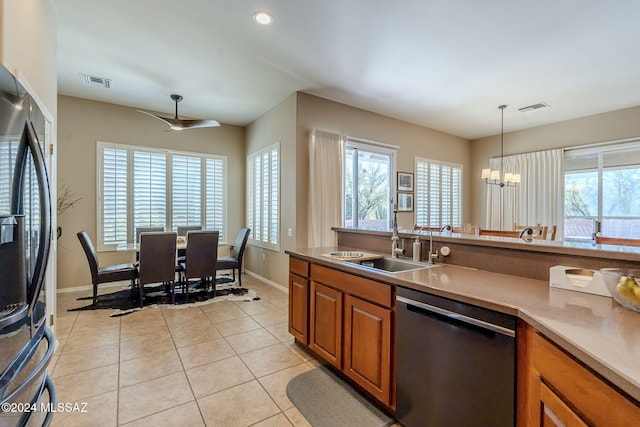 kitchen featuring sink, stainless steel dishwasher, a notable chandelier, fridge, and decorative light fixtures