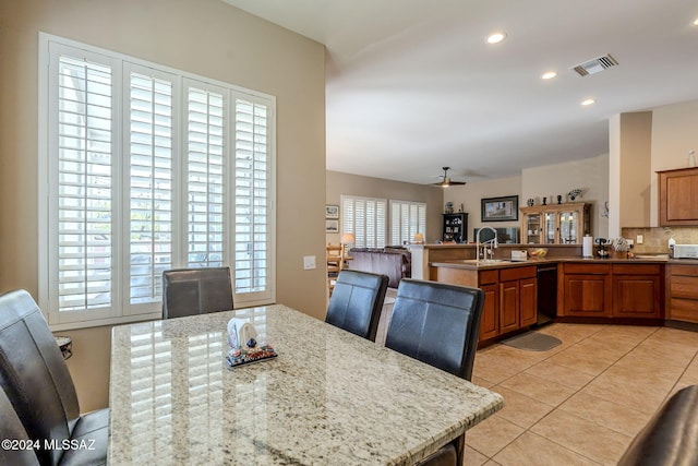 dining area featuring ceiling fan, sink, and light tile patterned flooring