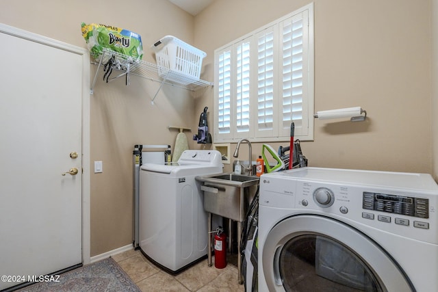 laundry room featuring washing machine and clothes dryer, sink, and light tile patterned floors