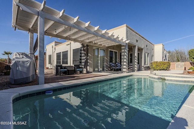 view of swimming pool with area for grilling, a patio area, and a pergola