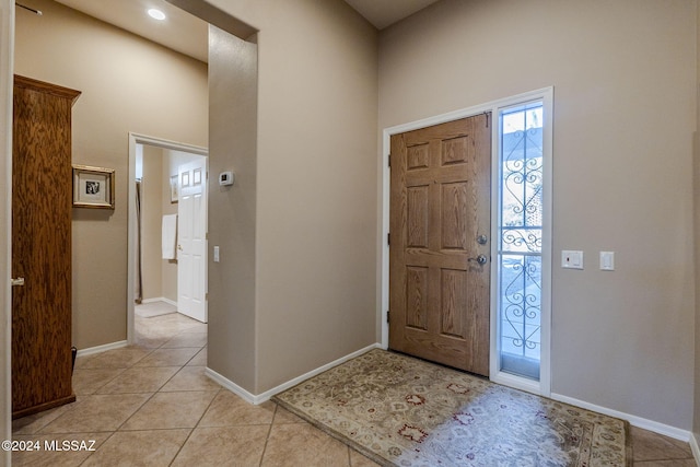 entrance foyer with a towering ceiling and light tile patterned floors