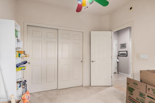 bedroom with ceiling fan, a closet, and light carpet