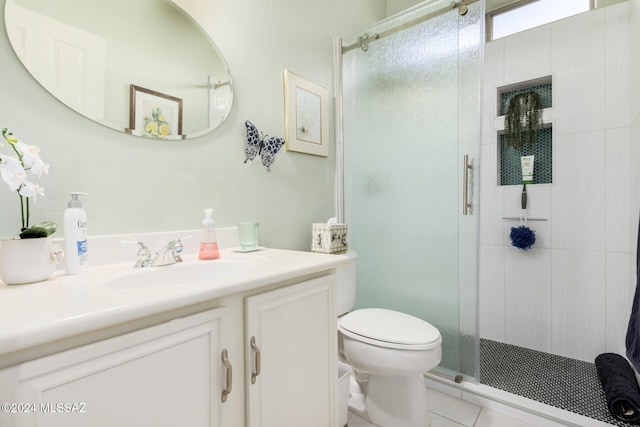 bathroom with tile patterned flooring, vanity, toilet, and walk in shower