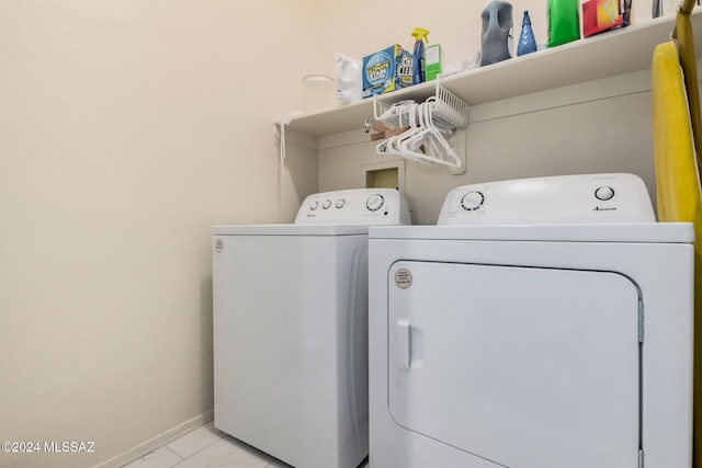 laundry area featuring washing machine and dryer and light tile patterned flooring