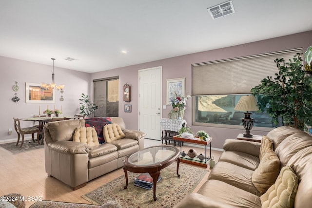 living room with light hardwood / wood-style floors and a notable chandelier