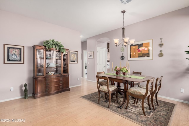 dining area featuring light wood-type flooring and a chandelier