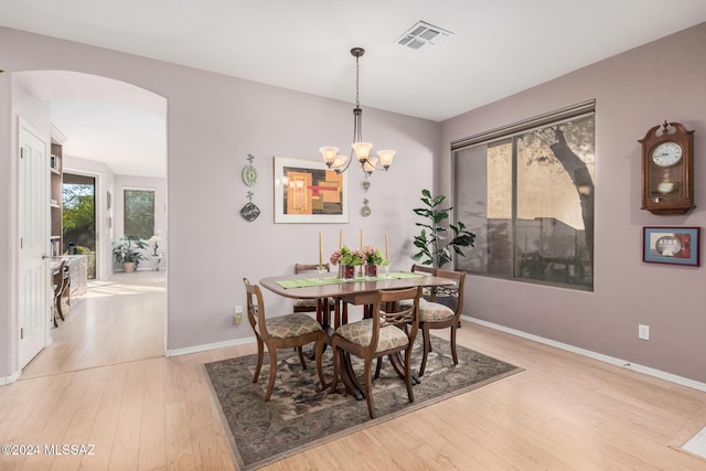 dining space featuring light wood-type flooring and a chandelier