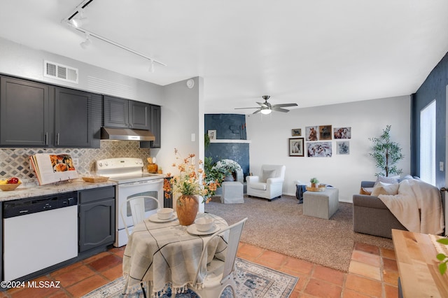 kitchen featuring track lighting, backsplash, white appliances, light stone counters, and ceiling fan