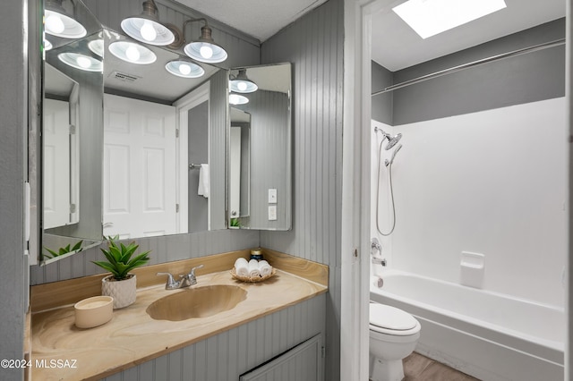 full bathroom with washtub / shower combination, vanity, toilet, and a skylight