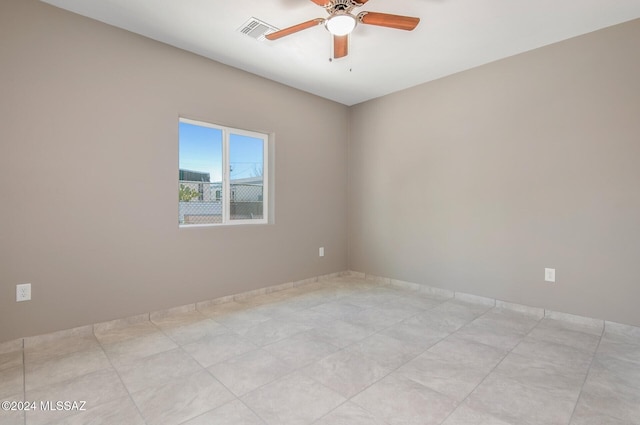 empty room with ceiling fan and light tile patterned flooring