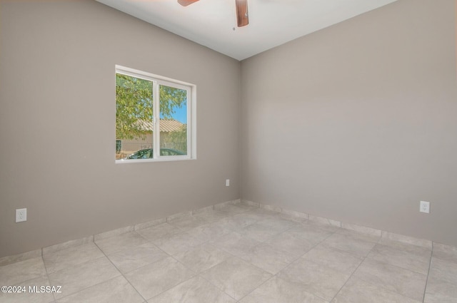 spare room with ceiling fan and light tile patterned floors