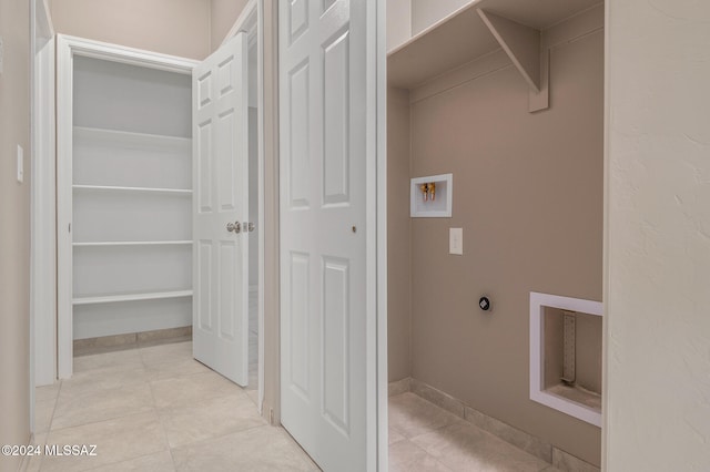 laundry room with hookup for an electric dryer and light tile patterned floors