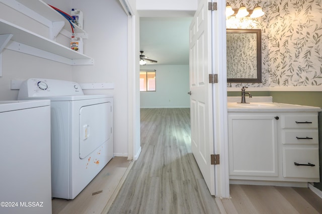 laundry area featuring ceiling fan, light wood-type flooring, separate washer and dryer, and sink