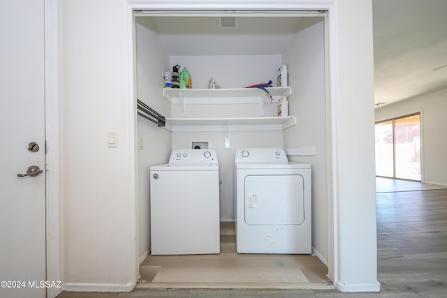 laundry area featuring separate washer and dryer and light hardwood / wood-style floors