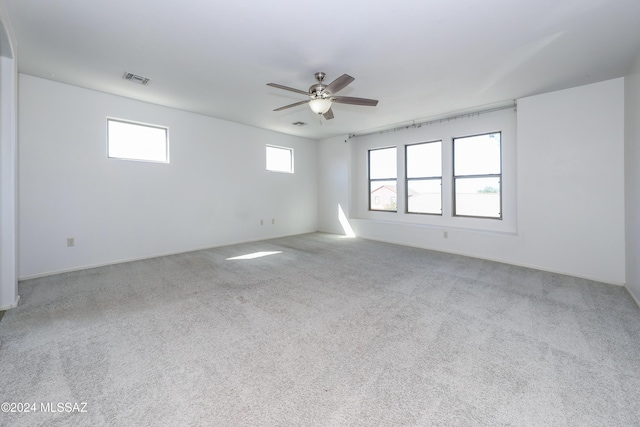 carpeted spare room with ceiling fan